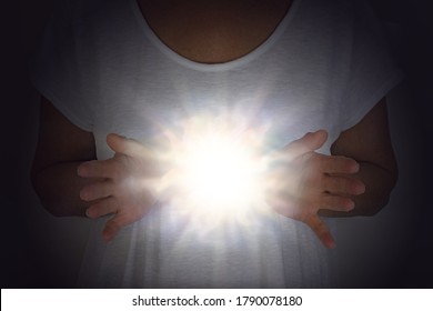 High Resonance White Light Healing Energy Phenomenon  - female in white tunic with hands apart at chest level with a bright shining white orb light between 
