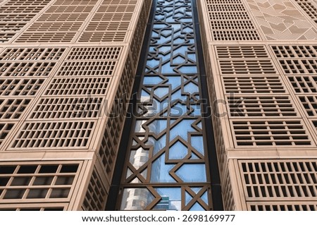High rise Building facade pattern. Contemporary glass building facades with reflections, modern urban architecture and geometric design in Abu Dhabi UAE. Abstract architecture background