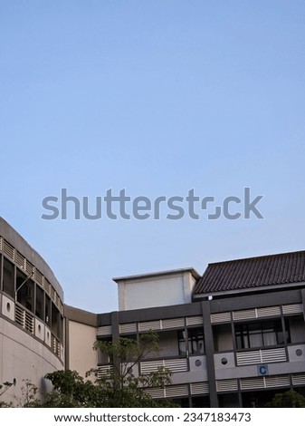  high rise curve
glass building and dark steel
window system on blue clear sky
background,Business concept of
future architecture,lookup to the angle
of the corner building,