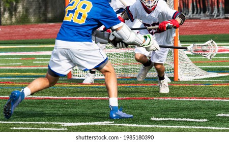 A High Schhol Boy Lacrosse Player Taking A Shot On Goal During A Game.