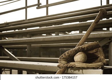 High school baseball practice with ball in glove and bat on bleachers.  