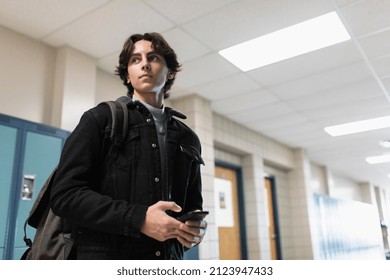 High school boy student using smart phone in corridor - Shutterstock ID 2123947433