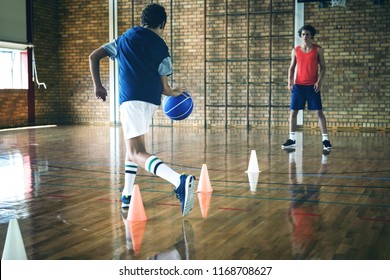 High school boys practicing football using cones for dribbling drill in the court - Powered by Shutterstock