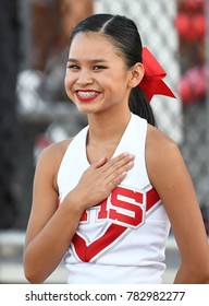 High School Cheerleader With Hand Over Heart for the National Anthem