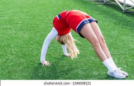 A High School Cheerleader Warming Up On A Green Turf Field In A Back Bend Bridge Position Before She Does A Walk Over.