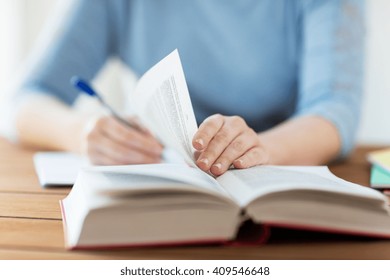 High School, Education, People And Learning Concept - Close Up Of Young Student Or Woman With Book Writing To Notebook At Home