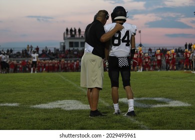 A high school football coach talks to a player - Powered by Shutterstock