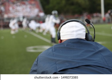 A High School Football Coach Watches The Line Of Scrimmage