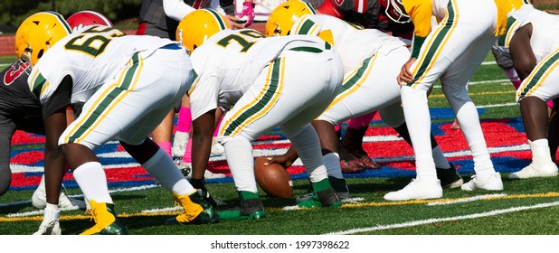 High School Football Players On The Ine In A Three Point Stance Ready To Snap The Ball And Start The Next Play.