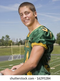 High School Football Players In Stands With Field In Background.