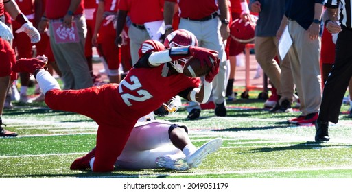 A High School Football Running Back Diving Into The Endzone For A Touchdown During A Game.