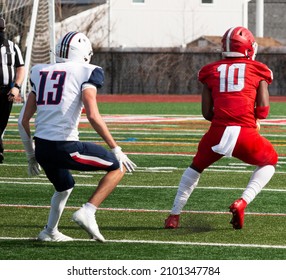 High School Football Wide Receiver Catching The Ball In Front Of The Defender Making A Move To Run Down The Field.