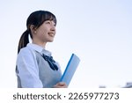 A high school girl in uniform looking far outside