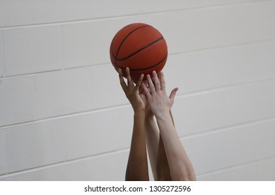 High School Girls Basketball Players Hold Up A Ball Prior To A Game