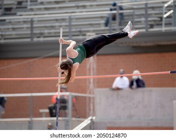 High School Girls Competing In Pole Vault At A Track And Field Meet