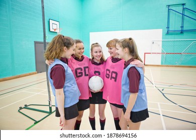 High School Girls With A Netball Standing In A Huddle Before A Game.