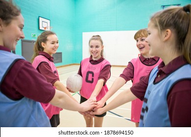 High School Girls With A Netball Touching Hands In Huddle Before A Game.