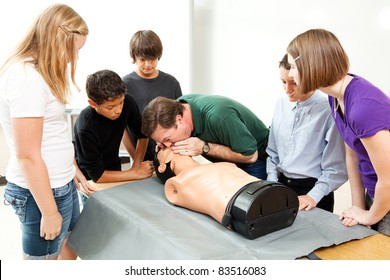 High School Health Class Instructor Demonstrates CPR Lifesaving Techniques For His Students.