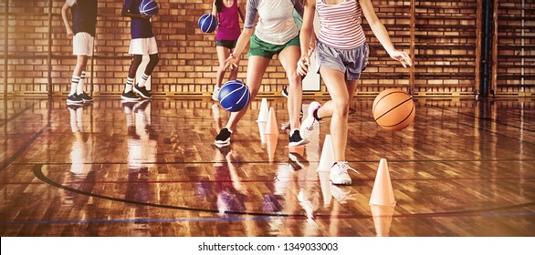 High school kids practicing football using cones for dribbling drill in the court - Powered by Shutterstock