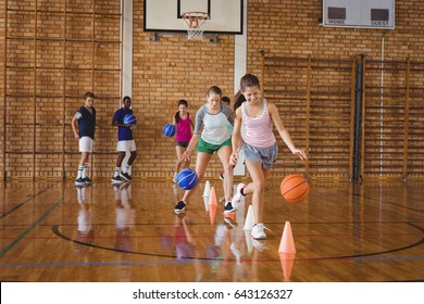 High school kids practicing football using cones for dribbling drill in the court - Powered by Shutterstock