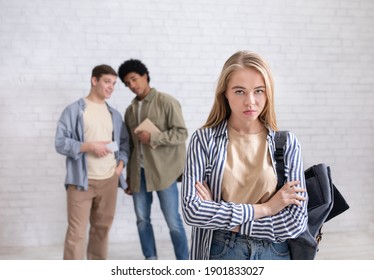 High school lady being bullied, pressure and humiliation by classmates. Multiracial teen males offend upset lady with backpack in school or college, on white wall background, studio shot, empty space - Powered by Shutterstock