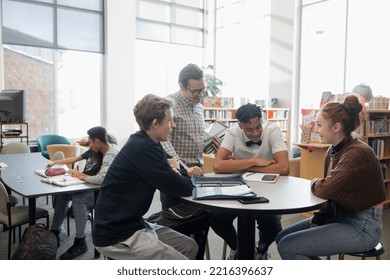 High school librarian and students talking in library - Shutterstock ID 2216396637