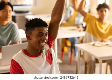 In high school, smiling teenage boy raising hand in classroom with classmates. Education, learning, student, teenager, participation, knowledge - Powered by Shutterstock