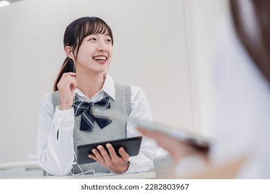 A high school student communicating with a foreign student using a translation app - Shutterstock ID 2282803967