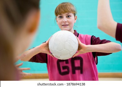 High School Student Holding A Netball During A Match In A Gym Class.