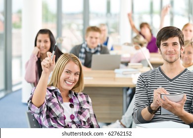 High School Student Raising Hands In Classroom