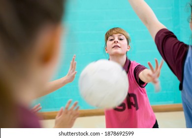 High School Student Throwing A Netball During A Match In A Gym Class.