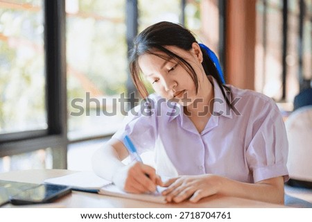 high school student working, do home work, writing project at school campus library