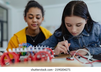 High school students building and programming electric toys and robots at robotics classroom - Powered by Shutterstock