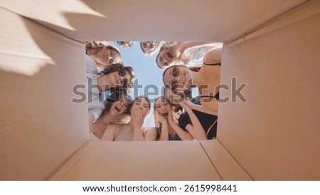 High school students eagerly looking inside a big cardboard box, uncovering a summer break surprise