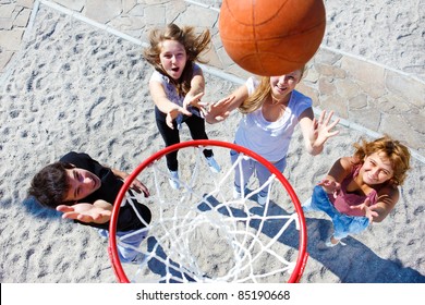 High School Students Playing Basketball In Park