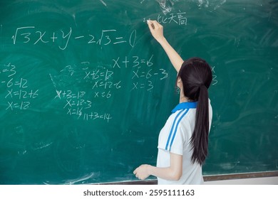 High school students solving math problems on the blackboard in classroom during class