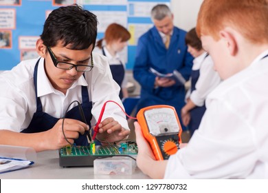 High school students using volt meter in electronics class