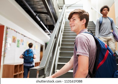 High School Students Walking Down Stairs In Busy College Building