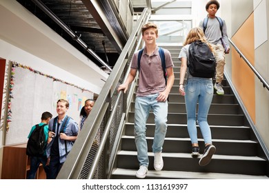 High School Students Walking Down Stairs In Busy College Building