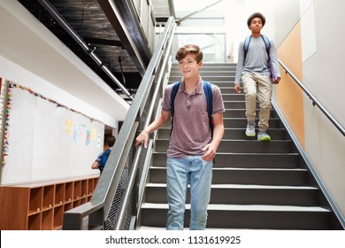 High School Students Walking Down Stairs In Busy College Building