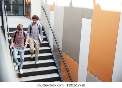 High School Students Walking Down Stairs In Busy College Building