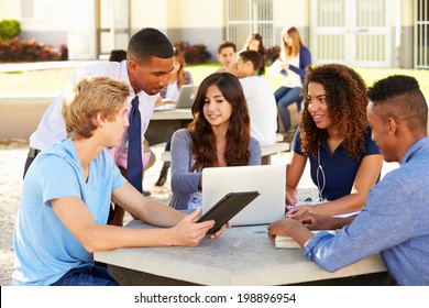 High School Students Working On Campus With Teacher