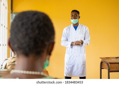 High School Teacher In Africa Wearing A Lab Coat And Face Mask In Class Talking To The Class Pupils