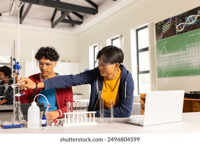 In high school, teenagers conducting science experiment with lab equipment and laptop. Education, STEM, laboratory, technology, teamwork, students - Powered by Shutterstock