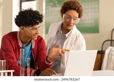 In high school, teenagers using laptop and discussing science project in laboratory. Education, students, teamwork, research, technology, discussion - Powered by Shutterstock