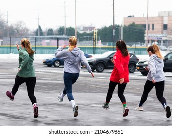 High School Track Runners Running Speed Drills In A Wet And Icy Parking Lot After A Winter Snow Storm.