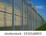 High security fence with spiky Nato wire rolls on top at a German prison in Hanover, Lower Saxony, Germany. Barbed wire to stop prisoners from escaping.