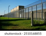 High security fence with spiky Nato wire rolls on top at a German prison in Hanover, Lower Saxony, Germany. Barbed wire to stop prisoners from escaping.