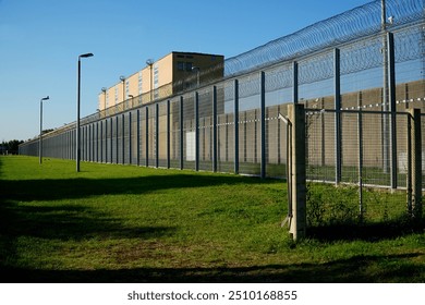 High security fence with spiky Nato wire rolls on top at a German prison in Hanover, Lower Saxony, Germany. Barbed wire to stop prisoners from escaping.