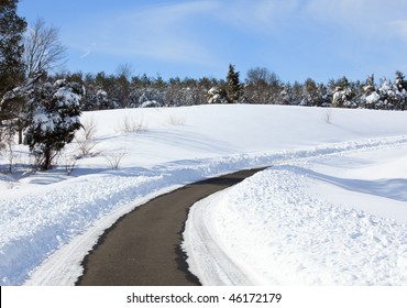 High Snow Banks By Side Of Road Leading Up A Hill After Recent Plowing